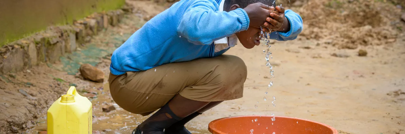 Patenkind Isabelle aus Ruanda wäscht sich mit sauberem Wasser.