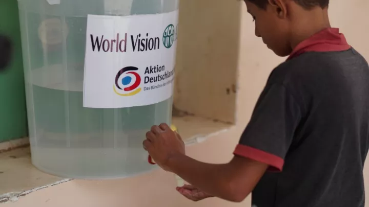Junge im Jemen zapft sauberes Trinkwasser