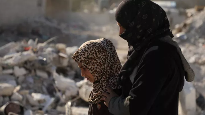 Tochter und Mutter vor Trümmern in Nordwestsyrien