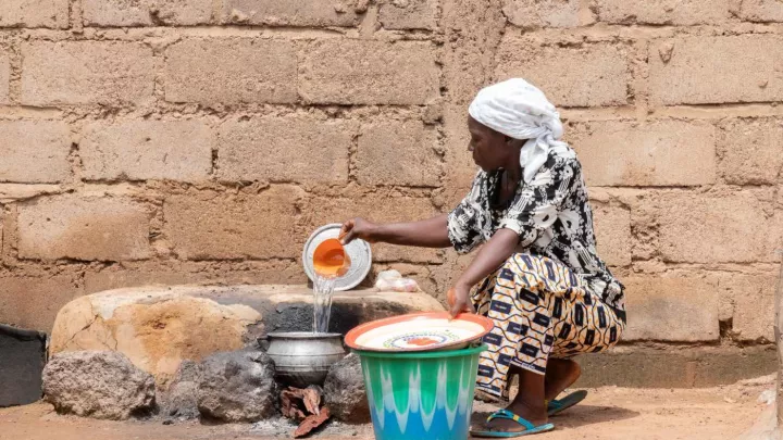 Eine afrikanische Frau schöpft Wasser