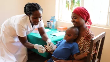 Mutter mit Kind bei einer Gesundheitshelferin in Tansania